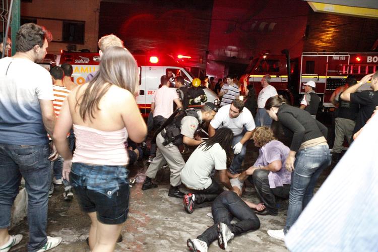 DISKOTEKSBRAND. Tilskadekommen mand fra Kiss-natklubben i Santa Maria i Brasilien hjælpes af omkringstående. 