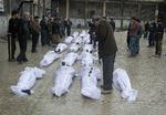 massakre. Syrere undersøger ofrene for en massakre i Aleppo for at se, om deres savnede er iblandt. 