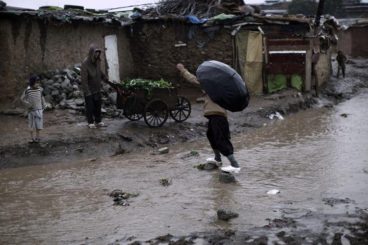 Vådt. Regnvejret laver gaderne om til små floder mange steder i Pakistan. Her er vi i et slumkvarteret uden for Islamabad. 