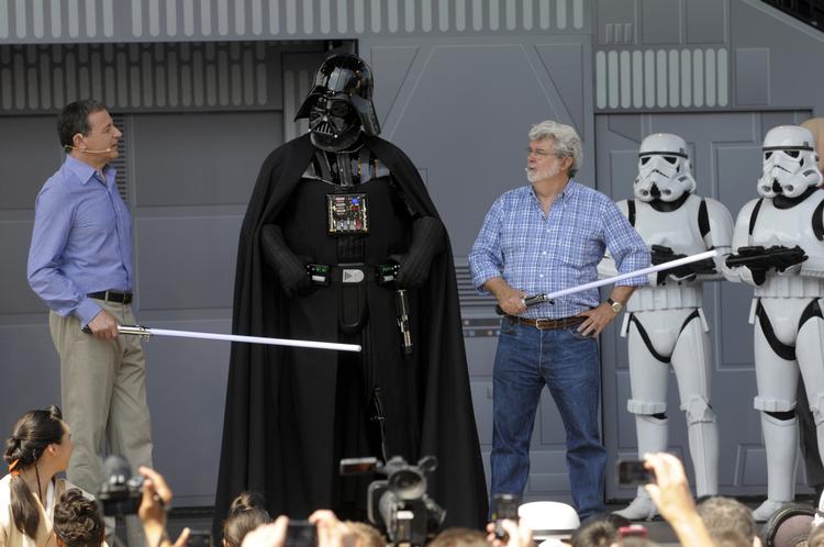 Ond. Måske det bliver selveste Darth Vader, som får sin egen film? Det er ham i midten. Manden i blå skjorte til højre for ham er hans skaber, George Lucas, og på venstre hånd står hans nye ejer, Disnyes topchef, Robert Iger. 