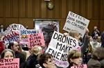 Protestaktion. Demonstranterne blev hurtigt vist ud af fra Senatshøringen om droneangreb. 