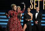 Gimmick. Adeles prisoverrækkelse forløb ikke helt som planlagt, men her har sangeren fået sin Grammy. I baggrunden Pitbull og Jennifer Lopez. 