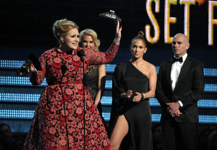 Gimmick. Adeles prisoverrækkelse forløb ikke helt som planlagt, men her har sangeren fået sin Grammy. I baggrunden Pitbull og Jennifer Lopez. 