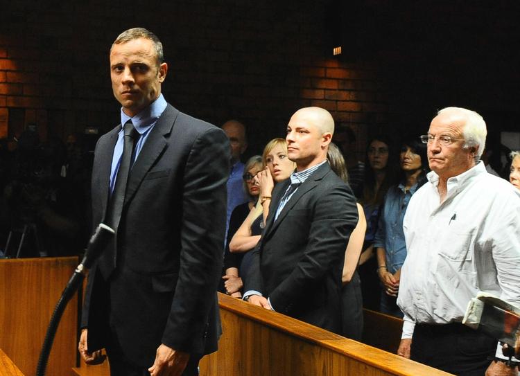 drabssag. Oscar Pistorius (tv) kunne slet ikke forstå, at han var anklaget for drabet på sin modelkæreste, da han blev fremstillet i retten. Til højre ses løberens bror og far. 