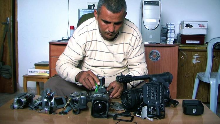 Smadrede. Emad Burnat med de fem kameraer, der er blevet ødelagt af israelerne under optagelserne til dokumentaren, hvis titel netop her til. 