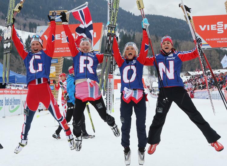 N-O-R-G-E. Midt i jublen over VM-guldet i langrendsstafetten stod de norske kvinder lidt forkert, for at kunne skrive 'NORGE' - og så manglede de træneren. Marit Bjørgen hopper længst mod venstre. 