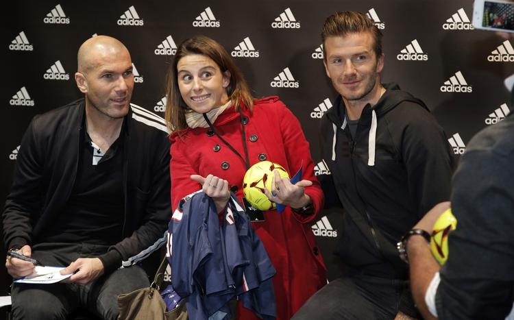midtpunkt. Placeret mellem to stjerner. Denne franske fodboldfan troede nok ikke på sit held, da hun på Champs Elysees i Paris pludselig sad mellem Zinedine Zidane (tv) og David Beckham (th). 