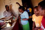 Frygten. George Kungu (bagerst til venstre) er slagter i Nairobis største slumkvarter, Kibera. Billedet er fra i lørdags, hvor han var ved at planlægge lukningen af butikken. 
