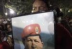 Farvel. En kvinde holder et skilt af den afdøde leder i Venezuelas hovedstad, Caracas. 