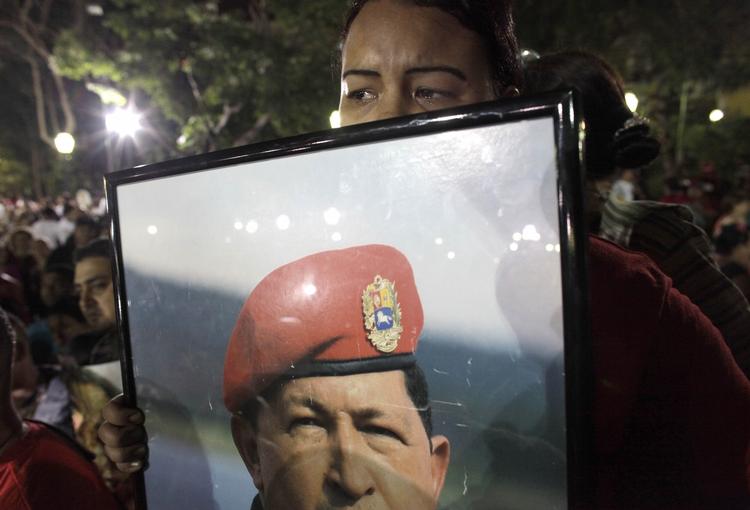Farvel. En kvinde holder et skilt af den afdøde leder i Venezuelas hovedstad, Caracas. 