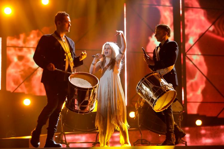 SS-uniformer. Her ses Emmelie til generalprøven før det danske Melodi Grand Prix, med trommeslagerne i de SS-lignende kostumer. Det, der gør, at de minder om de tyske uniformer fra 2.Verdenskrig, er båndet omkring nederste del af venstre ærme, som kan anes her på billedet. Se også illustration nedenfor. 