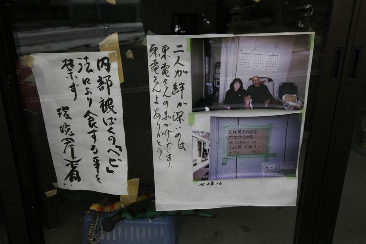 Protestskilte mod firmaet Tepco, der var ansvarlige for driften af Fukushima atomkraftværket, ses i vinduet til en ejendom, hvor beboerne er evakueret. 