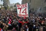 74. Så mange blev dræbt under Egyptens største fodboldulykke i historien. Her holder en tilhænger af Kairo-klubben Al-Ahly et banner, der ærer sine medtilhængere, der blev dræbt under ulykken i februar 2012. 