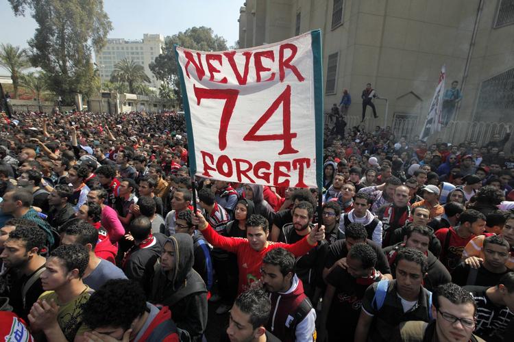 74. Så mange blev dræbt under Egyptens største fodboldulykke i historien. Her holder en tilhænger af Kairo-klubben Al-Ahly et banner, der ærer sine medtilhængere, der blev dræbt under ulykken i februar 2012. 
