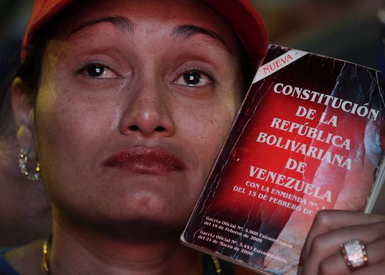 Sorg. En kvinde knuger sig til et eksemplar af Venezuelas forfatning uden for parlamentet, hvor Nicolas Maduro blev taget i ed som ny præsident. 