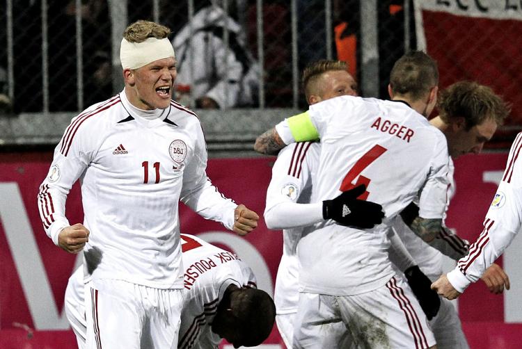 Jaaaa. Andreas Cornelius skriger sin glæde ud, mens Daniel Agger og de øvrige holdkammerater krammer hinanden. 