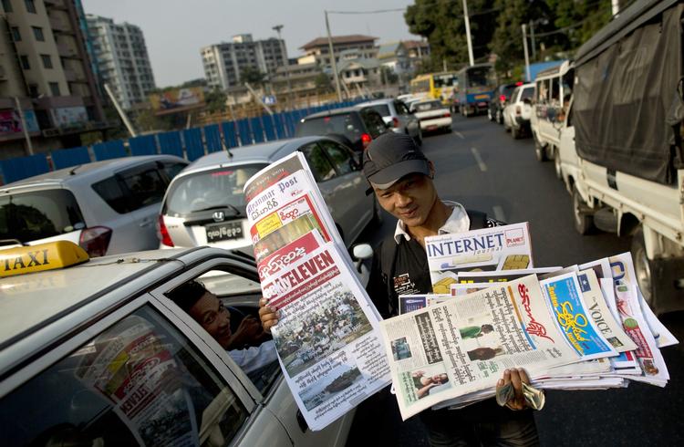 Køb. Der sælges frie, privatejede aviser på gaden i Rangoon, hovedstadeni  Myanmar. 