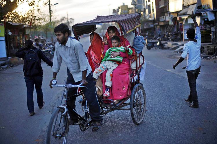 Protest. En demonstrant (th.) i New Delhi demonstrerer efter voldtægt af en syvårig, mens en rickshaw passerer. 