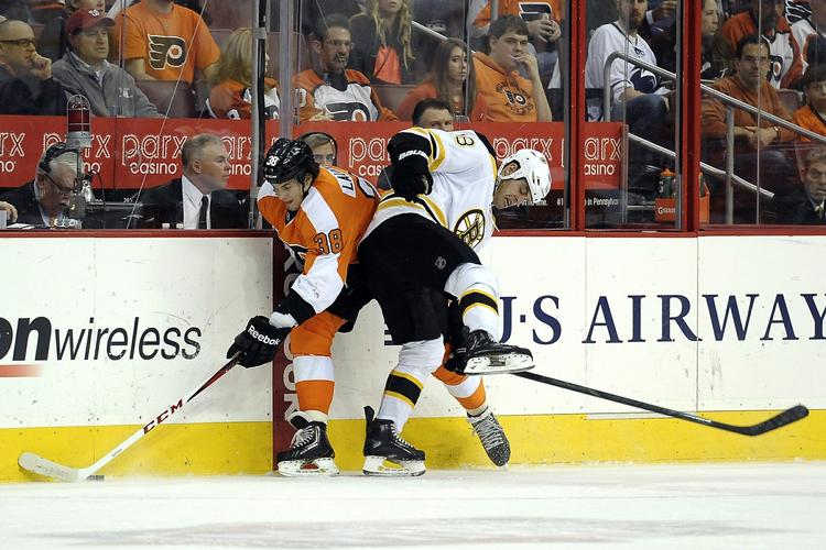 kæmpe. Oliver Lauridsen (tv) bliver presset op mod banden i kampen mod Boston Bruins. 