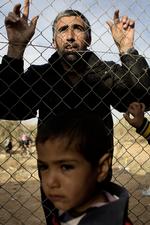 Indhegnet. Lejren i Zaatari er bevogtet og omkranset af hegn og pigtråd. Her kigger en af de mange gæster, der ofte rejser langt for at besøge pårørende i lejren. 
