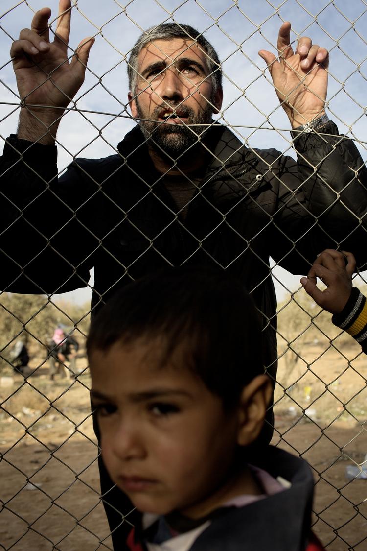 Indhegnet. Lejren i Zaatari er bevogtet og omkranset af hegn og pigtråd. Her kigger en af de mange gæster, der ofte rejser langt for at besøge pårørende i lejren. 