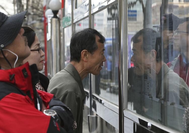 HVERDAG. Sydkoreanerne går på arbejde og passer deres gøremål, siger Danmarks ambassadør i Seoul. Her læser sydkoreanere forskellige aviser, der fortæller om Nordkoreas seneste trusler. 