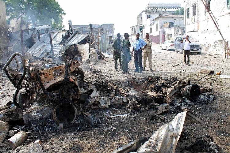 Internationalt. Somaliske soldater ved et bilvrag, hvori en bombe i dag detonerede. 