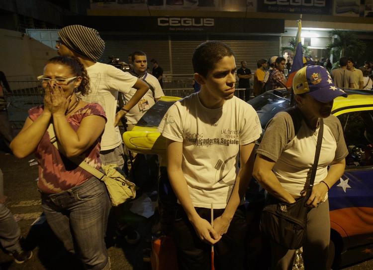 Øv. Tilhængere af kandidaten Henrique Capriles lytter skuffet til valgresultatet i Venezuela. 