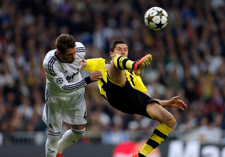 0-0. Real Madrids anfører Sergio Ramos (tv) kæmper om bolden med Robert Lewandowski, som ikke så meget til bolden i første halvleg af semifinalen i Madrid. 