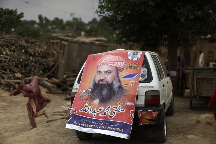 Valg. Vold og drab forud for dagens pakistanske valg. Her passer en pige en plakat for Mohammed Abdullah, der stillet op for det pro-Talebanske Jamiat-e-Ulema Islam (JUI-F). 