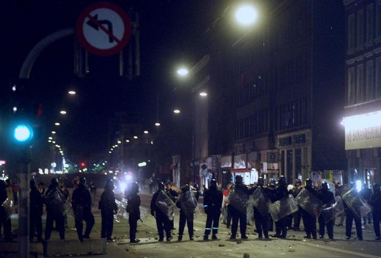 Her afventer politiet situationen ved krydset Nørrebrogade/Fælledvej. 