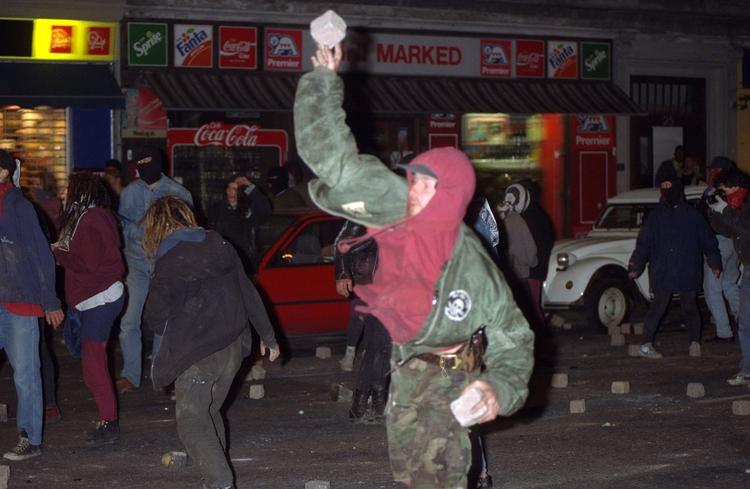 Da politikæden går op ad Fælledvej, angriber demonstranterne, de kaster bl.a. brosten mod betjentene. 