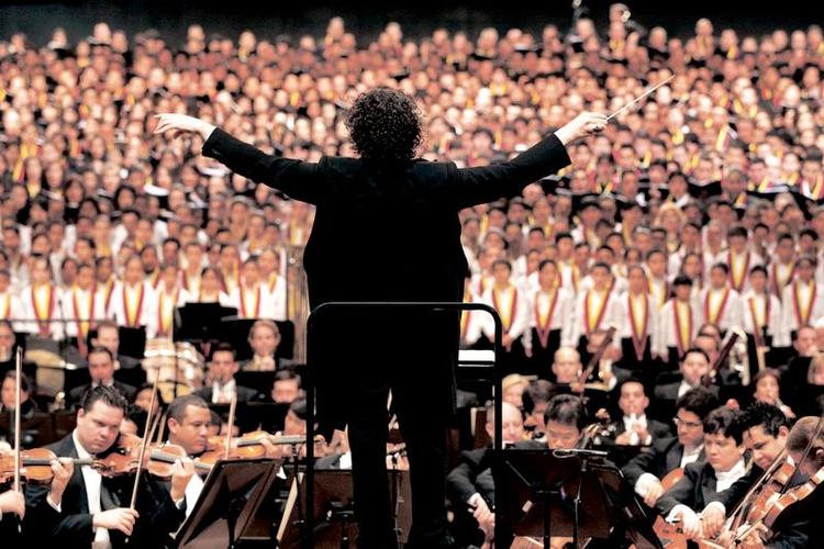 Vingefang. Gustavo Dudamel foran et udsnit af de medvirkende i Mahlers 8. Symfoni i Caracas. 
