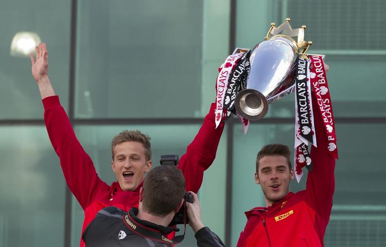 rivaler. Manchester Uniteds målmænd, David De Gea (th) og Anders Lindegaard med trofæet efter klubbens seneste mesterskab. 