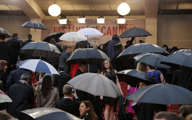 Lørdag aften i Cannes var en våd affære. Her ankommer folk til visningen af Arnaud Desplechins 'Jimmy P.'. 