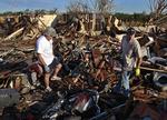 ØDELÆGGELSER. Tornadoen ødelagde mange hjem. Her er det far og søn, der er ved at gennemsøge et tidligere hjem. 