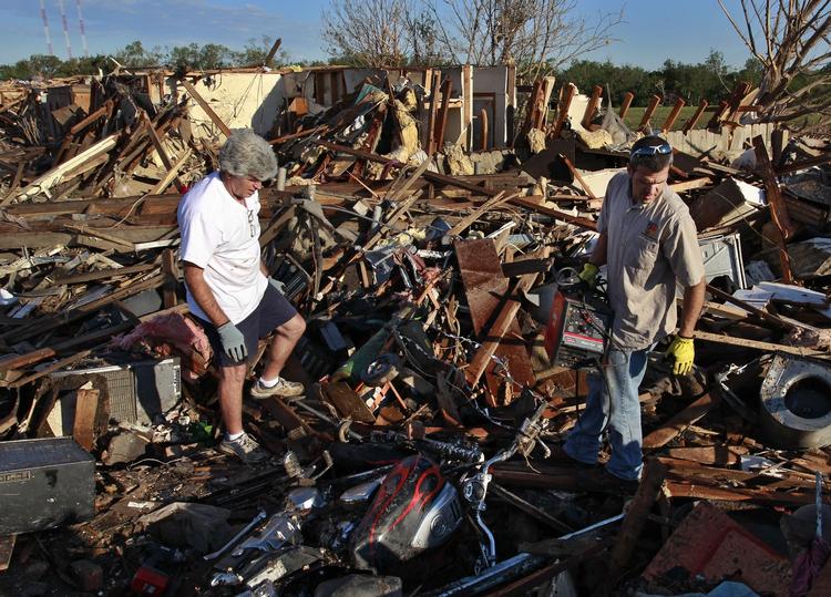 ØDELÆGGELSER. Tornadoen ødelagde mange hjem. Her er det far og søn, der er ved at gennemsøge et tidligere hjem. 