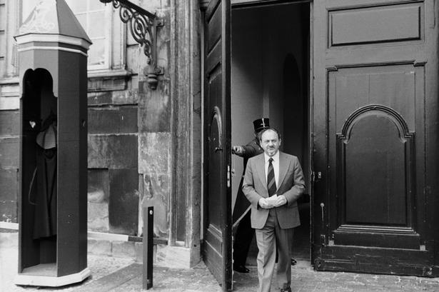 Statsminister Anker Jørgensen, da han i 1979 kommer ud af porten på Amalienborg, hvor han netop har indgivet regeringens afskedbegæring til dronning Margrethe. 