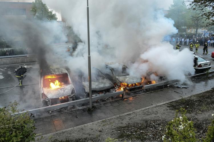 Ballade. Brandfolk slukker brændende biler i Stockholm-forstaden Rinkeby efter endnu en nat med hærværk. 
