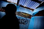 Pusher. En anonym pusher på arbejde under kasket i en hashbod bag kamouflagenet og isolationsmåtter. Med udsigt til Pusherstreet som nu går højsæsonen i møde. Foto: Martin Lehmann 