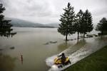 Firehjulet motorcykel på en oversvømmet vej ved Lauerzeesee i Schweiz. 
