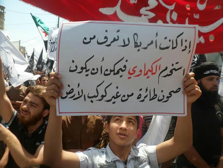 Protest. »Hvis Amerika ikke ved, hvem der brugte de kemiske våben, kunne det være flyvende tallerkener fra en anden planet«, står der på plakaten under en demonstration i Sarmada i den syriske provins Idlib. 
