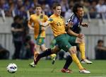 1-1. Japans Shinji Okazaki (th) tackles af Australiens Matthew Mckay under kampen i Saitama ved Tokyo. 
