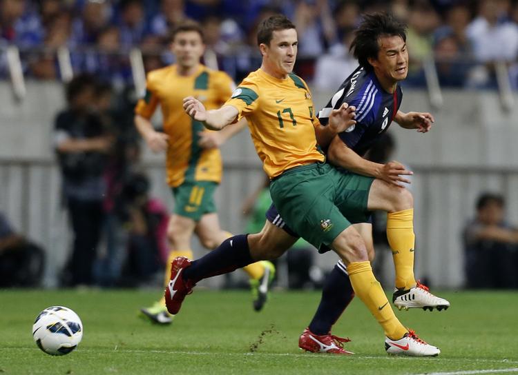 1-1. Japans Shinji Okazaki (th) tackles af Australiens Matthew Mckay under kampen i Saitama ved Tokyo. 