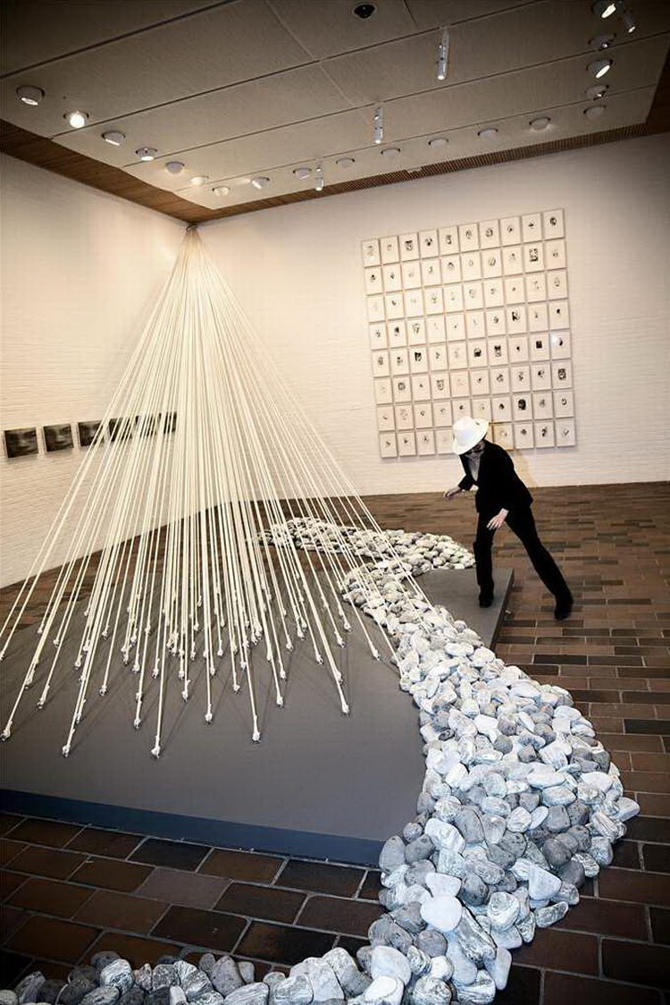 PERFORMER. Yoko Ono er en sand performer, som det ses her, hvor hun poserer ved siden af den smukke installation 'Morning Beams/Riverbed' fra 1996. I baggrunden ses en række tegninger udført gennem mange år, nu ophængt på rad og række på Louisiana. 