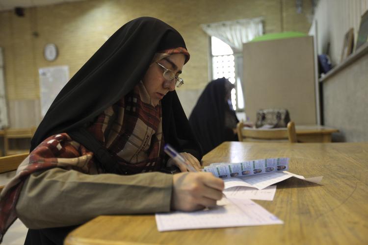 Valg. Iranske kvinder udfylder stemmesedler i et valglokale i Teheran i dag. 
