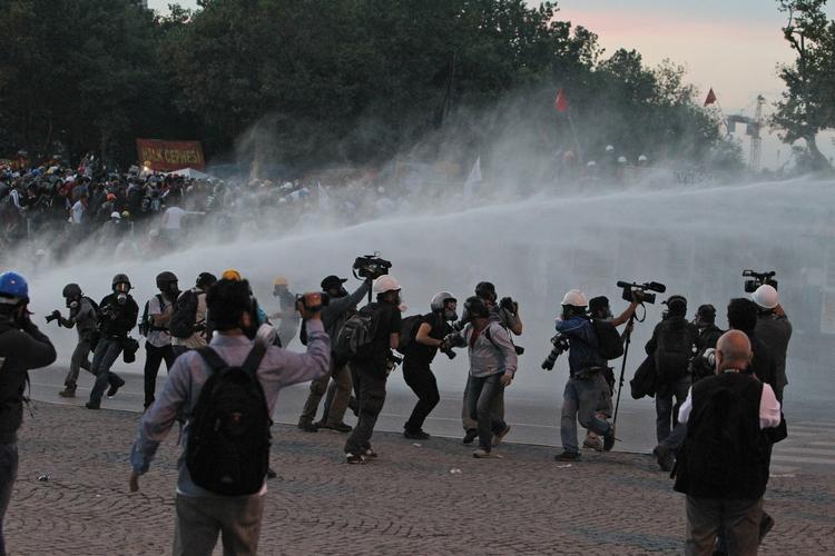 Demonstranter og pressefolk spredes for alle vinde, da politiet affyrer vandkanoner i forbindelse med rydningen af Geziparken og Taksimpladsen. 