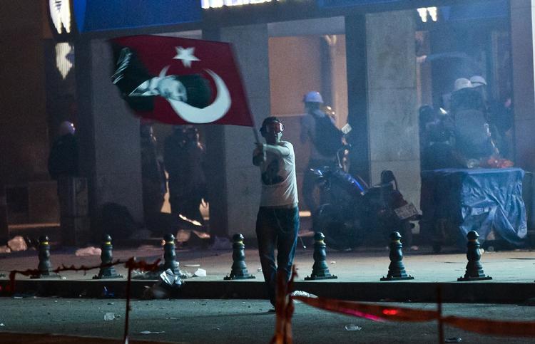 En demonstrant svinger det tyrkiske flag i nærheden af Geziparken i Istanbul, hvor demonstrationerne begyndte i protest mod byggeplaner i parken. 