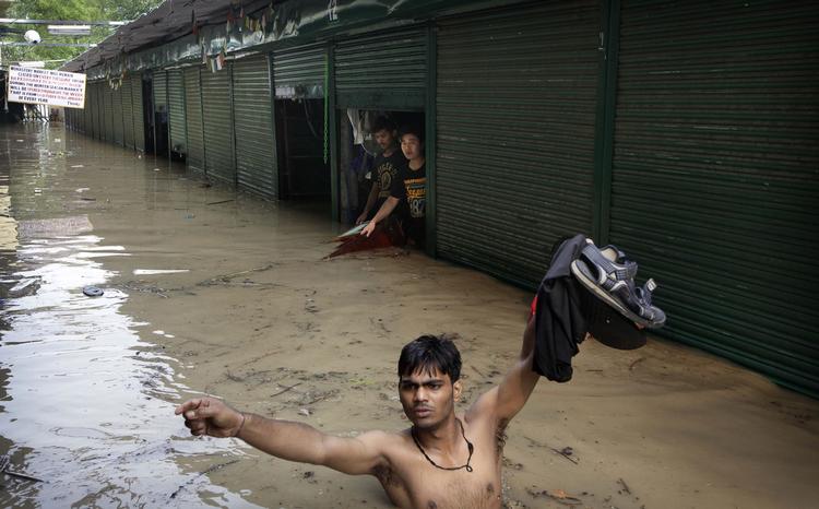 oversvømmet. En mand søger et sikkert sted i New Dehli, hvor Yamuna-floden er gået over sine bredder. 