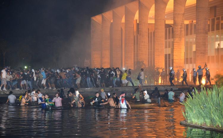 storm. Demonstranter kastede brændende genstande og knuste vinduer i Brasiliens udenrigsministerium, før politiet drev dem tilbage. 